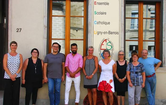 L'équipe de l'association devant l'Ensemble Scolaire Catholique